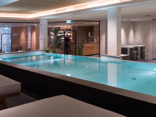 a large blue swimming pool in a building at Elite Hotel Brage - Hotel & Spa in Borlänge
