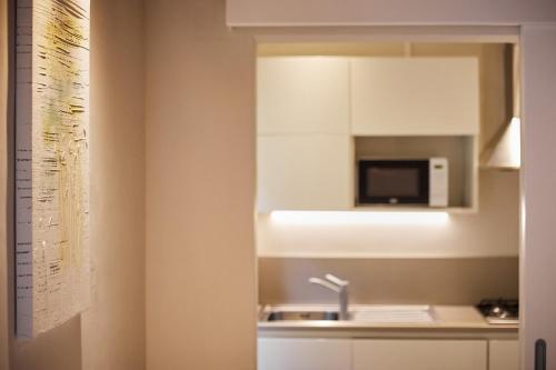 a kitchen with a sink and a microwave at Residenza Stuart - Blanche Stuart studio - Dimora storica in Montepulciano