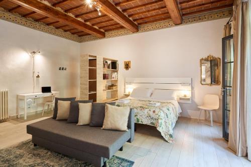 a bedroom with a bed and a couch and a desk at Residenza Stuart - Blanche Stuart studio - Dimora storica in Montepulciano