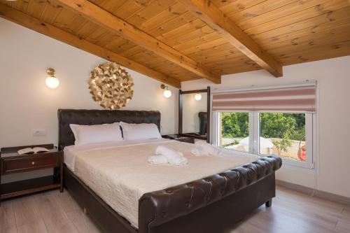 sypialnia z dużym łóżkiem i dużym oknem w obiekcie Garden Villa Chania w Chanii