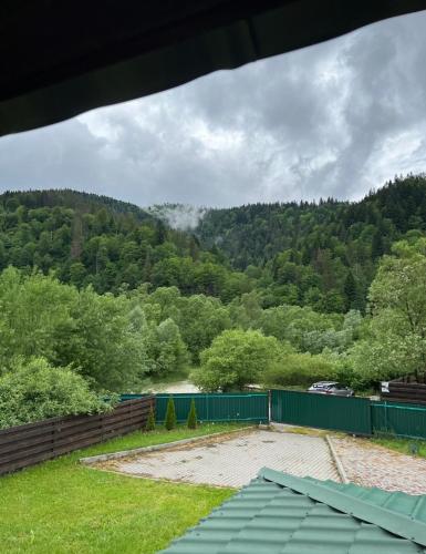 a view of a hill with a fence and trees at Veranda in Mykulychyn
