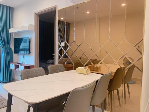 une salle à manger avec une table et des chaises blanches dans l'établissement Lahomestay Chỗ Nghỉ 2PN Tiện Nghi, Khách Hàng Yêu Thích, à Tân Vạn