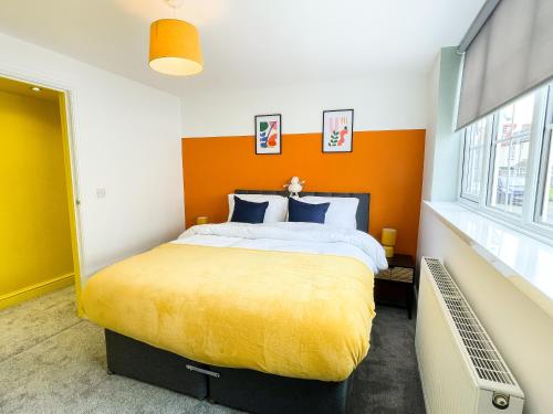 a bedroom with a large bed with an orange headboard at The New Found Lamb in Cleethorpes