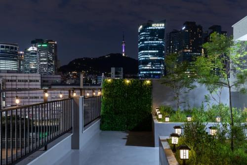 a balcony with a view of the city at night at Seoul Station Joey House in Seoul