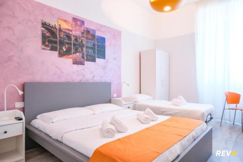 ローマにあるヴィアレ ジュリオ チェザーレ ゲストハウスのピンクの壁のベッドルーム1室(ベッド2台付)