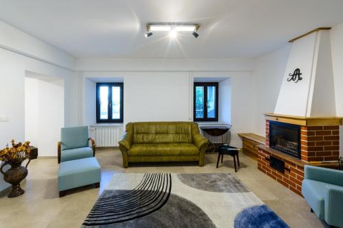 a living room with a couch and a fireplace at Guest House Žerjal in Podnanos