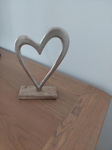a heart shaped metal object sitting on a wooden floor at Hédervári Lovas Vendégház in Hédervár