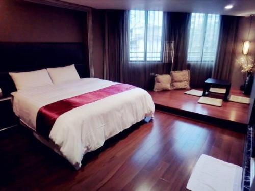 a bedroom with a large bed and wooden floors at Every Day Hot Spring Hotel in Jiaoxi