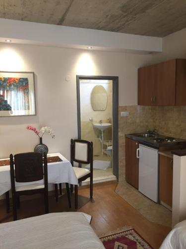 a kitchen and dining room with a table and a sink at Apartmani Padrov in Igalo