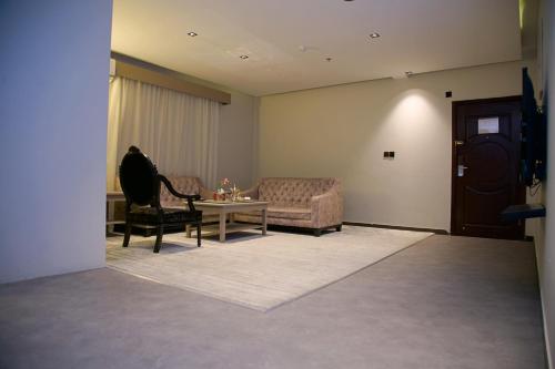 a living room with a couch and a table at Sharz Hotel in Buraydah