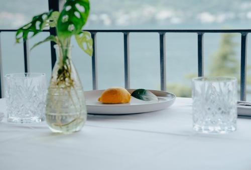 a table with a plate of oranges and a vase at Briisa De Ness in Nesso