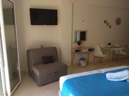 una camera con letto, sedia e televisore di Tzafi's Apartments 2 a Mesongi