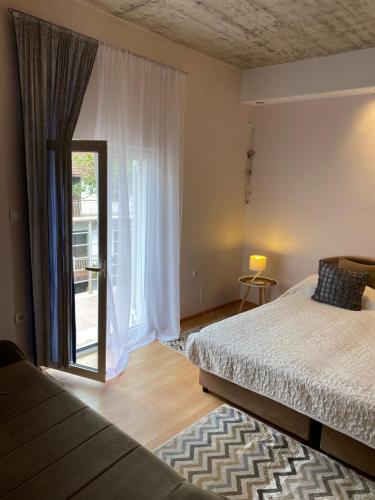 a bedroom with a bed and a large window at Apartmani Padrov in Igalo