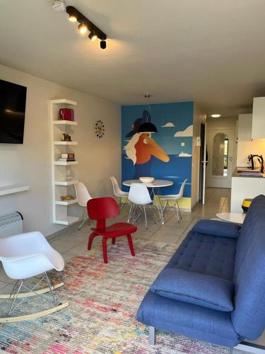 a living room with a blue couch and a table at Studio Blanchard in Koksijde
