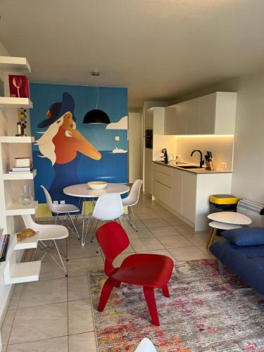 a living room with a table and chairs and a kitchen at Studio Blanchard in Koksijde