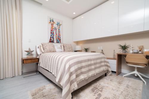 a bedroom with a bed and a desk and a chair at STUDIO apartment near Seven Mile Beach at The Grove in Upper Land