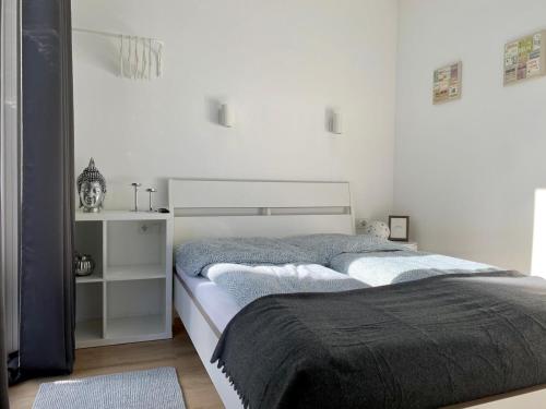 a bedroom with a bed and a white wall at Tiny Haus Liederbach in Alsfeld