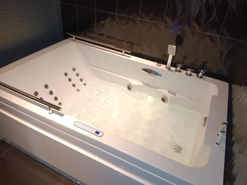 a white bath tub in a bathroom at Park Jizan Hotel in Jazan