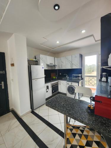 a kitchen with white appliances and a counter top at FamilyConfort Saidia in Saidia 