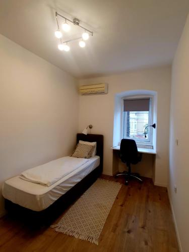 a bedroom with a bed and a desk and a window at Nice 2 bedroom apartment near city center in Rijeka