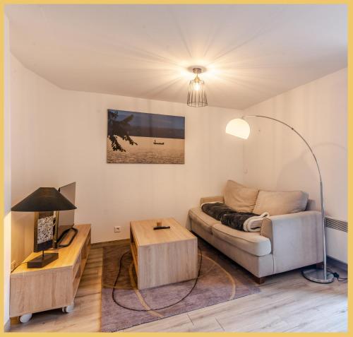 a living room with a couch and a table at Maison en Duplex I Yvoire I Lac Léman I Médiévale in Yvoire
