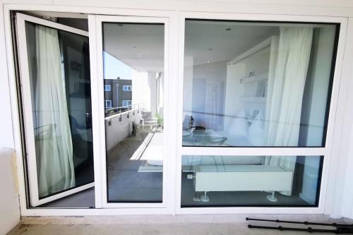 a room with two large sliding glass doors at Hamburg 04 Modernes Apartment am Winterhuder Marktplatz Alster Stadtpark in Hamburg