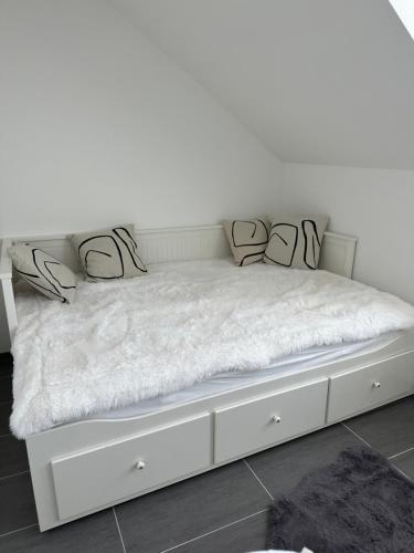 a white bed with white sheets and pillows on it at Appartement 2 in Bersenbrück