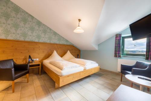 a hotel room with a bed and a desk and chairs at Allgäu-Hotel-Elbsee in Aitrang