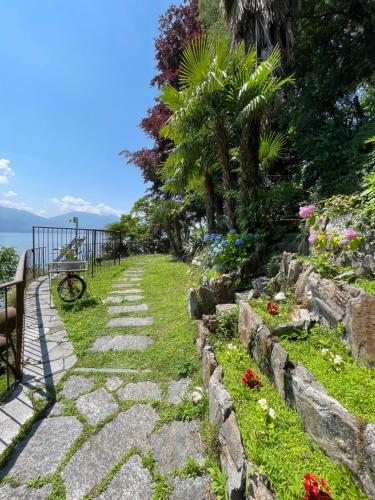 einen Steinweg, der zu einem Garten mit Blumen führt in der Unterkunft Villa Angelina Guest House in Cannero Riviera