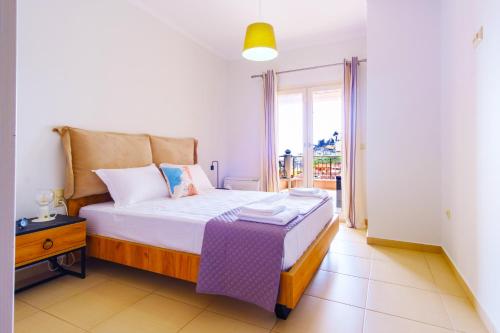 una camera con un grande letto e un balcone di Anthi Luxury Apartments a Párga