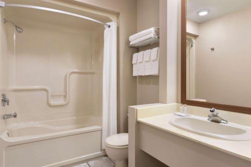 a bathroom with a sink and a toilet and a shower at Travelodge by Wyndham Simcoe in Simcoe