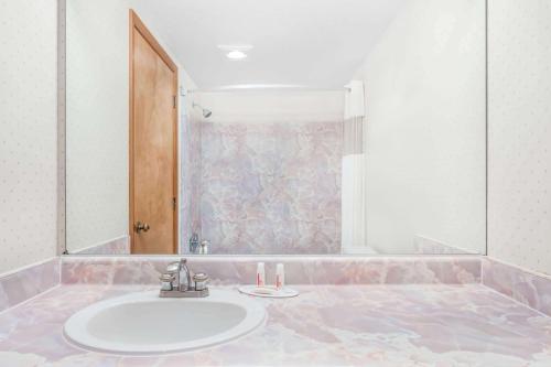 een badkamer met een wastafel en een douche bij Travelodge by Wyndham Juneau in Mendenhaven