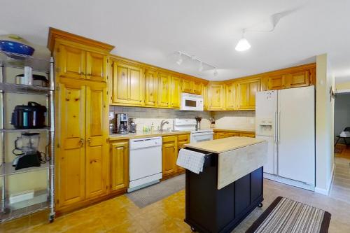 una cucina con armadi in legno e frigorifero bianco di The Huber Haven a Thurman