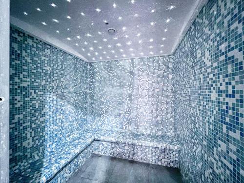 a bathroom with blue tiled walls and a ceiling with lights at Vivid 2-bedroom Marina view in Dubai