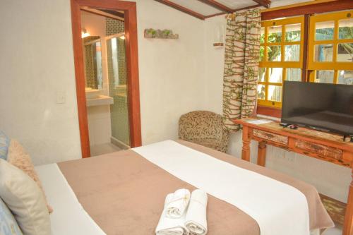 a bedroom with a bed with two shoes on it at Villa Geriba in Búzios