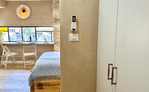 a room with a bed and a kitchen with a table at Boutique apartment in heart of Haifa in Haifa