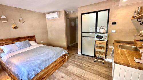 a small bedroom with a bed and a sink at Boutique apartment in heart of Haifa in Haifa