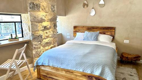 a bedroom with a bed and a stone wall at Boutique apartment in heart of Haifa in Haifa