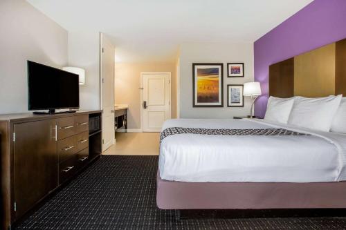 a hotel room with a large bed and a flat screen tv at La Quinta by Wyndham Pomona in Pomona