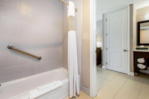 a bathroom with a tub and a shower curtain at La Quinta by Wyndham Pomona in Pomona