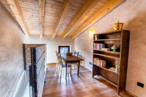 a dining room with a table and a book shelf at Le Camere di Marietta in Rovere Veronese