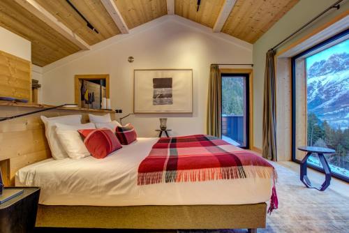 a bedroom with a bed and a large window at Le Chalet Mont Blanc in Les Houches