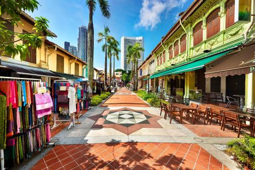 eine Straße in einer Stadt mit Tischen, Bänken und Gebäuden in der Unterkunft Andaz Singapore A Concept by Hyatt in Singapur