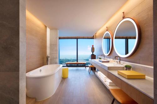 a bathroom with a tub and two sinks and a large window at Andaz Singapore A Concept by Hyatt in Singapore