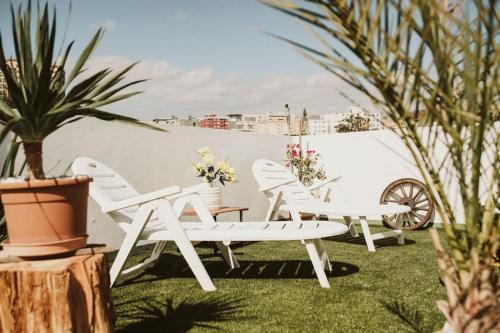 a group of white chairs and tables in a yard at Apartamento de la Candelaria I in Santa Cruz de Tenerife