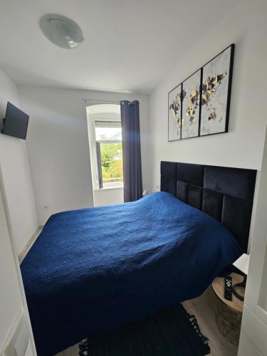 Un dormitorio con una cama azul y una ventana. en Apartment Oliver, en Rijeka