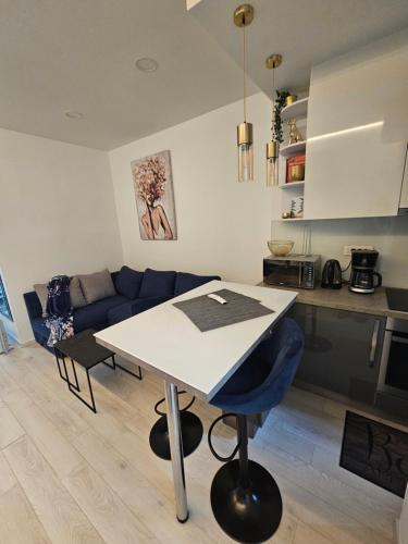 Una cocina y una sala de estar con una mesa y un sofá azul. en Apartment Oliver, en Rijeka