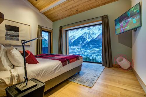 a bedroom with a bed and a large window at Le Chalet Mont Blanc in Les Houches