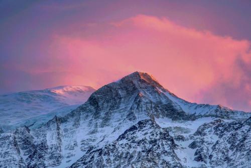 a mountain covered in snow under a pink sky at Le Chalet Mont Blanc in Les Houches