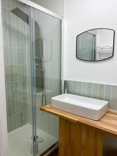 une salle de bain avec un lavabo et une douche en verre dans l'établissement La maison des trois mâts, à Rochefort